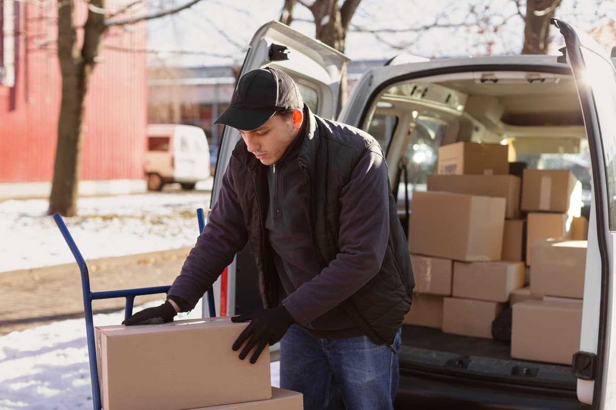 Courier lifting a box from the back of a van